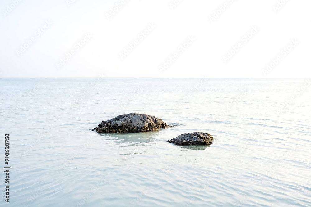 Sticker Two rocks in calm sea water