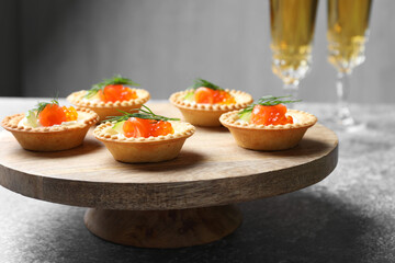 Delicious canapes with salmon and red caviar on gray table, closeup
