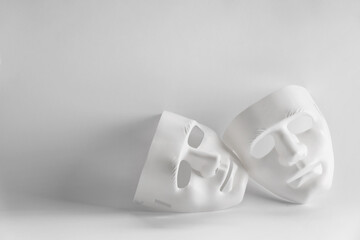 Plastic face masks on white background, space for text. Theatrical performance
