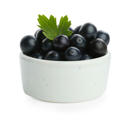 Bowl of ripe blackcurrants and green leaf isolated on white