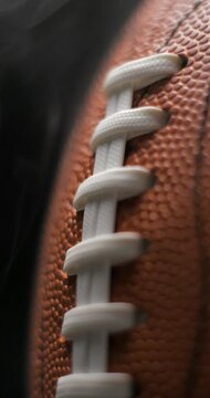 Football ball macro rotating with smoke in studio slow motion, vertical view