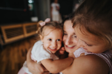 A loving mother hugging her two young daughters, capturing a tender and joyful family moment in a cozy home environment.