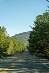 A winding road with view of mountains in White Mountain National Forest.