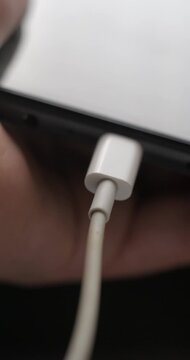 USB-C cable macro plugin to smartphone slow motion, vertical view