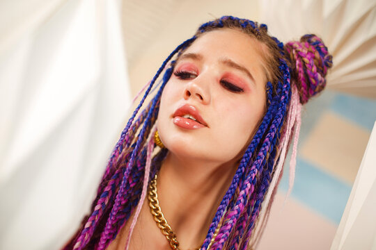 cheerful young woman wearing pink ress with dreadlocks in doll dress, party and carnival concept.