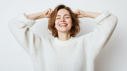 Fototapeta premium Joyful woman celebrating success with a bright smile in cozy sweater.