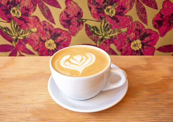 latte on table with floral wallpaper