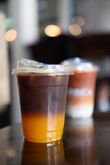 Iced americano or black coffee with orange juice in cafe. Summer trendy refreshing coffee drink
