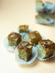 The square piece of soft banana cake served on paper cup. Selective focus. Close up.