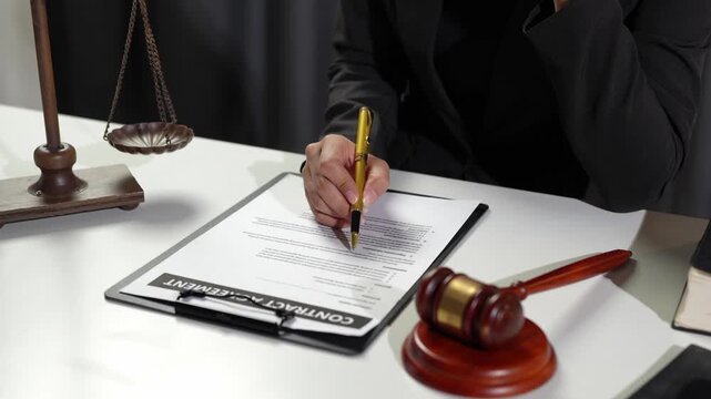 Lawyer, legal advisor Young businessman pointing at pen and reading agreement details Business contract for validity before signing financial contract inside office.