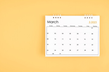 March 2025 desk calendar on yellow color background, position with copy space.