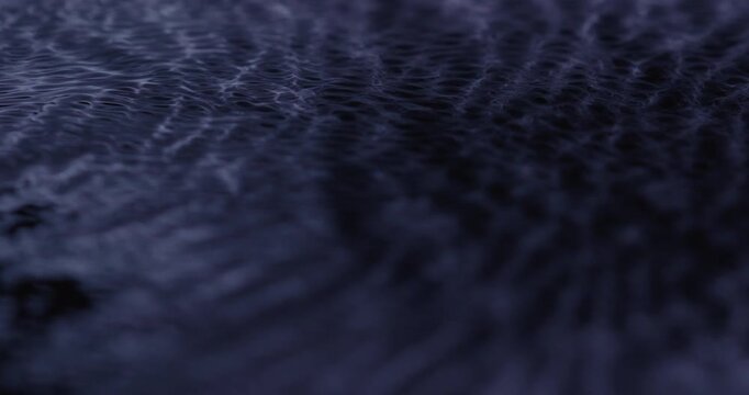 Macro shot of still black fluid beggining to ripple