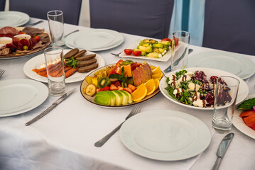 festive table set with Caesar salads, beets, fruit plate without people