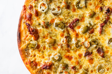 pesto pizza with olives jalapenos and sundried tomatoes