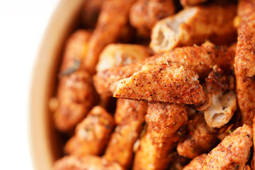 A bowl of Basreng (fried meatballs), a popular Indonesian snack made from thinly sliced fish meatballs, fried until crispy, and coated with spicy seasoning. Photographed against a white background.