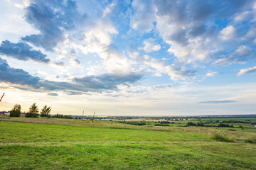 A large, open field with a clear blue sky and a few clouds