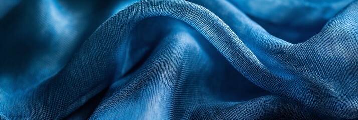 Fototapeta premium This image captures luxurious blue fabric draped artfully, highlighting the richness of the textile and its elegant and sophisticated texture.