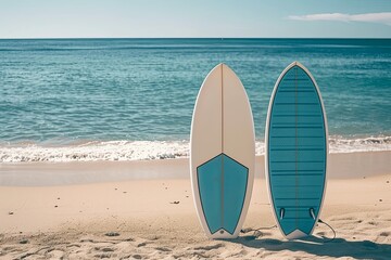 Two surfboards stand on sandy beach, ocean behind.