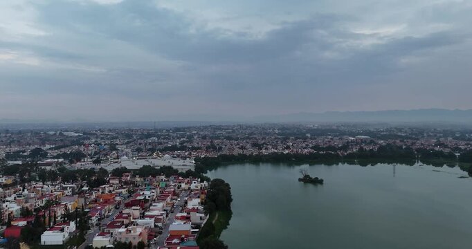 Drone flight shot flying over the limit of the Axotlan lagoon with the residential area in the northern area of ​​the metropolitan area of ​​Mexico City