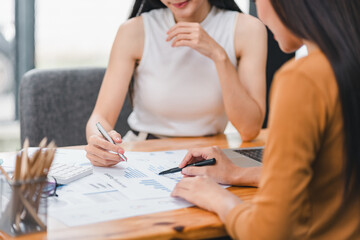 Two businesspeople or an accountant team are analyzing data charts, graphs, in order to prepare a statistical report and discuss financial data in an office.