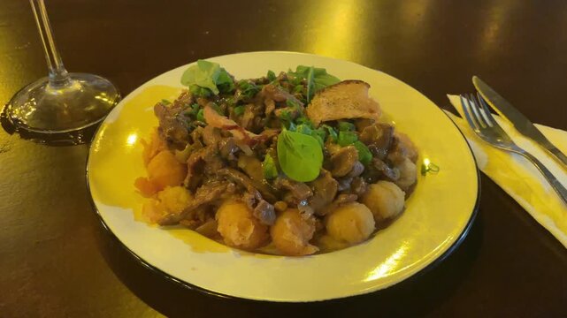 traditional dish in argentina meat and mashrooms stroganoff with potato ball food on plate in cafe amateur shot