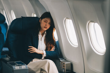 Fototapeta premium Photo of a frustrated woman sitting on an airplane with her head in her hands. Asian woman sitting in a seat in airplane