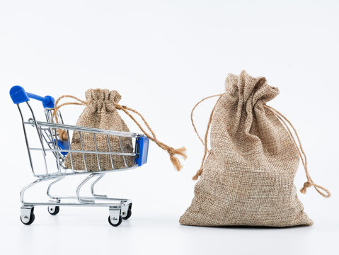 A smaller burlap sack in trolley and a bigger burlap outside of cart. Isolated with white background.
