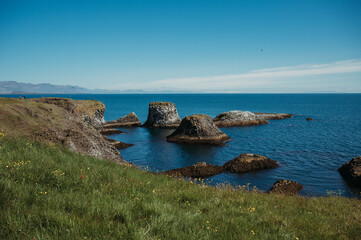 View on rugged rocks in Gatklett, Iceland, with clear blue ocean