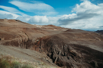 Volcanic mountains in Myvatn, Iceland under a blue sky with clouds