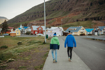 Brothers walking in colorful village in Seydisfjördur, Iceland