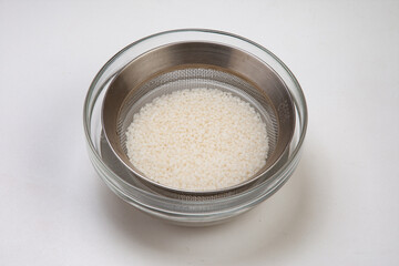 米と餅米を合わせてボウルに入れて、水を加えて浸しザルにあげておく