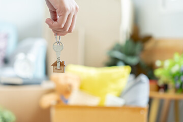 Moving house, relocation. Woman hold key house keychain in new apartment. move in new home. Buy or rent real estate. flat tenancy, leasehold property, new landlord, dwelling, loan, mortgage.