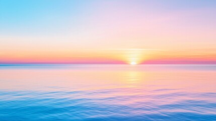 Obraz premium A beautiful sunset over a calm ocean, featuring vibrant hues of pink and blue reflected on the water's surface.