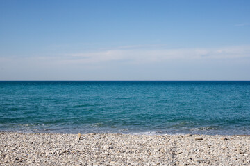 Seashore, small stones, sea wave. Marine background.