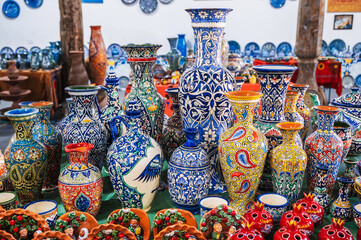 Colorful Asian Uzbek ceramic vases and jugs in the oriental shop at pottery workshop in Uzbekistan