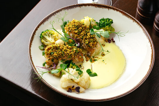 fried fish in a plate with sauce and garin cheese . restaurant m