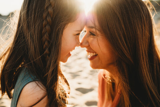 Close up of Mother daughter looking into eyes forehead together