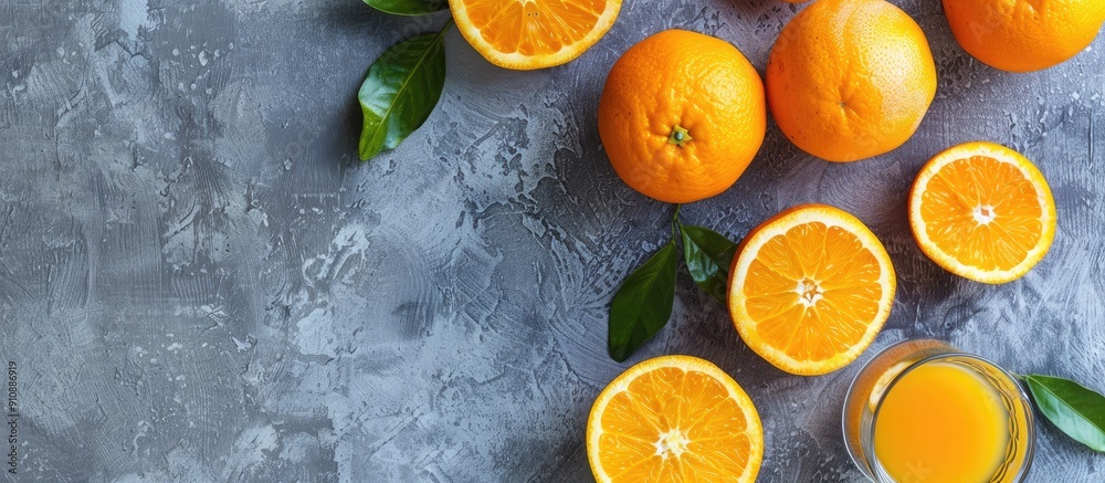 Poster Overhead view of fresh oranges on a gray background with a glass of orange juice allowing for copy space image