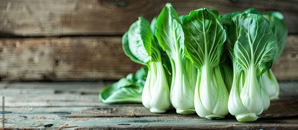 Poster copy space image of green bok choy or pac choi chinese cabbage on a wooden surface seen from the sid