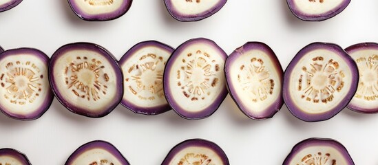 Eggplant slices arranged in circular pattern on white backdrop Isolated with copy space image for decorative frame or border on a food themed background