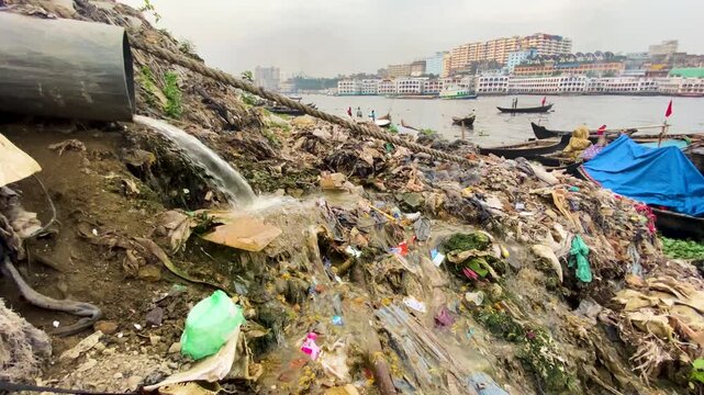 Dirty sewage water running down a huge hill of trash, river pollution in the Buruganga river, Dhaka, Bangladesh, slow motion