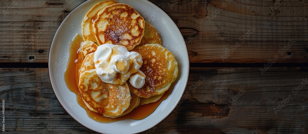 Poster view from above of light and fluffy cottage cheese pancakes or russian syrniki with sour cream and c
