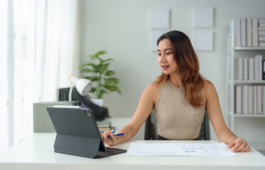 Fototapeta premium Asian businesswoman takes notes in an online meeting on the internet using her laptop. startup business idea Data Analysis, Business Owners, Marketing, Accounting, Auditing.