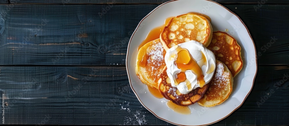 Poster view from above of light and fluffy cottage cheese pancakes or russian syrniki with sour cream and c