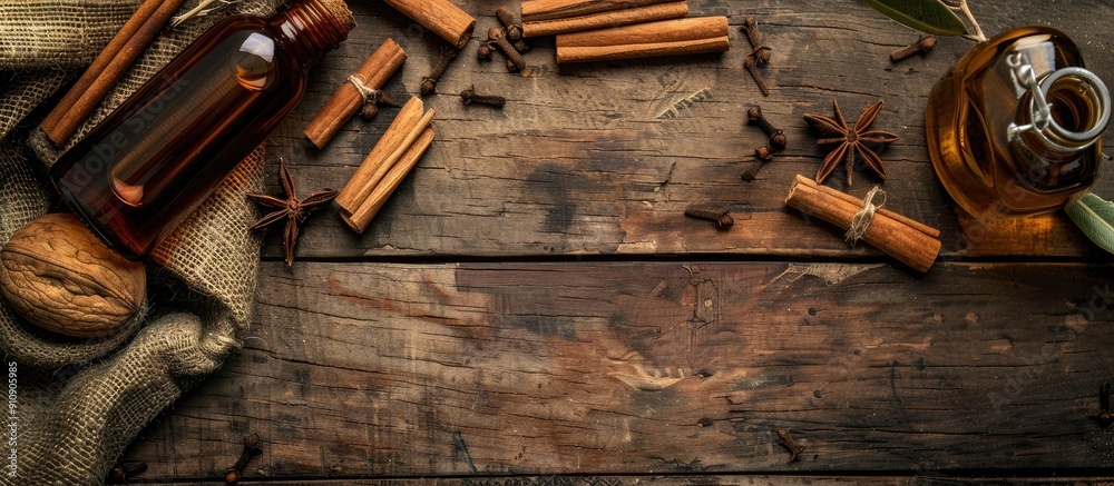 Aufkleber a wooden background with cinnamon sticks and aromatic essential oil for aromatherapy and organic cos