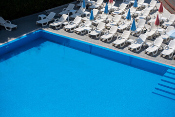 swimming pool with sun beds on resort