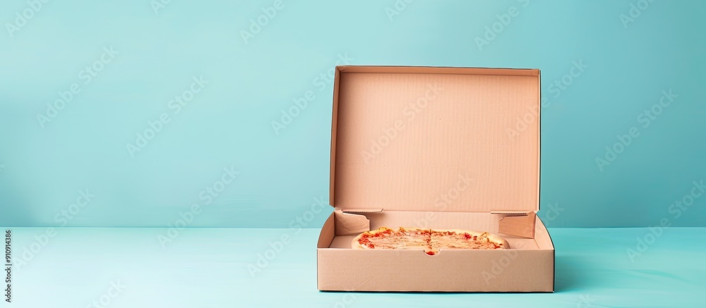 Fototapete pizza box on a light blue backdrop with empty copy space image