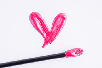 Pink liquid lipstick and applicator isolated on white background. Swatch of deep pink lip gloss. Top view, flat lay, copy space