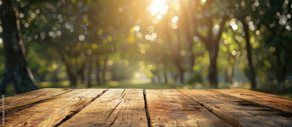 Fototapete Product displayed on a wooden table with a blurred background of trees with bokeh effect providing ample copy space image