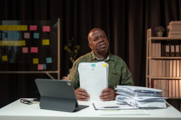 African American businessman tired, headache, stressed, worried about paperwork. Have aches and...